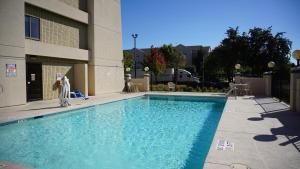 a person standing next to a swimming pool at Baymont by Wyndham Arlington At Six Flags Dr in Arlington