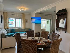 a living room with a table and chairs and a couch at MARINA SMIR - Beach Apartment in Marina Smir