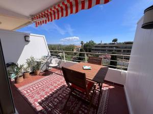 a balcony with a table and chairs and an umbrella at piscine, parking, vue mer, 23 m2 in Saint-Tropez