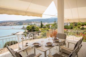 a table and chairs on a balcony with a view of the water at Sea La Vie in Agia Marina Aegina