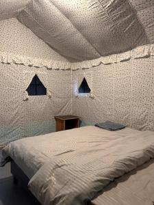 Un dormitorio con una cama en una tienda de campaña. en Monkey Mud House and Camps, Bir, en Bīr