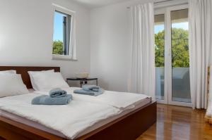 a bedroom with a large bed with towels on it at Modern Villa Krk in Gabonjin