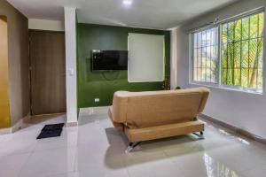 a living room with a couch and a flat screen tv at En el centro de cancún, cercano a zona hotelera in Cancún