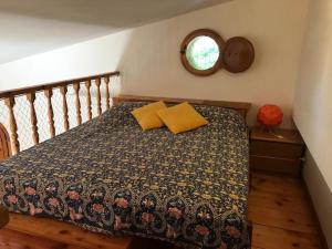 a bedroom with a bed with a blanket and a window at La casina - Castiglioncello in Castiglioncello