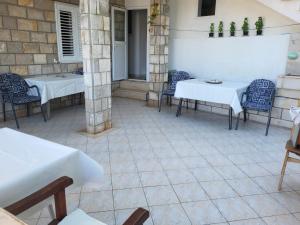 a patio with white tables and chairs on a building at Guesthouse Gravosa in Dubrovnik