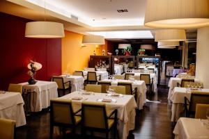 une salle à manger avec des tables, des chaises et un tissu de table blanc dans l'établissement Hotel Can Batiste, à Sant Carles de la Ràpita