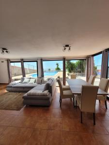 a large living room with a table and chairs at Sunset Paradise Villa with Heated Pool in Calheta