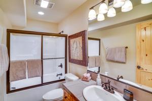un bagno con lavandino, WC e specchio di Duck Creek Village Cabin with Deck and Private Hot Tub a Duck Creek Village Altre 26 foto