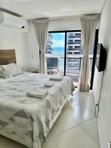 a bedroom with a bed and a large window at Landscape Diamond 1409 in Fortaleza +65 photos