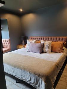 una camera da letto con un letto grande con cuscini sopra di al pie de las sierras en villa del lago a Tandil Altre 40 foto