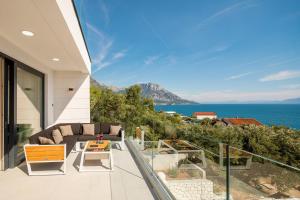 a balcony with a couch and a view of the ocean at Villa Luna Mare mit Pool und Sauna in Podaca