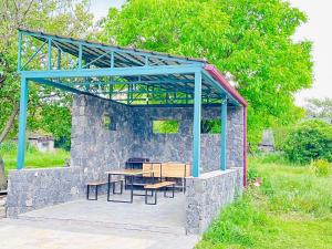 a stone building with a picnic table and benches at Canyon View Dsegh in Dsegh