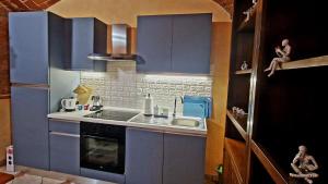 een kleine keuken met blauwe kasten en een gootsteen bij Monferrato AgriCottage Valentina in Calliano