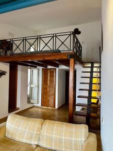 a living room with a couch and a spiral staircase at ALBACHIARA by CefaLux in Cefalù