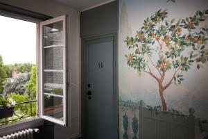 a hallway with a painting of a tree on the wall at Hôtel Marguerite in Orléans