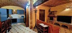 een woonkamer met een bank en een tv en een keuken bij Monferrato AgriCottage Valentina in Calliano