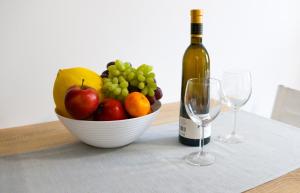 a bowl of fruit sitting next to a bottle of wine at Apartamenty INTERDOM in Zakopane +61 photos