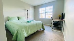 a bedroom with a bed and a desk and a window at Spacious room with Shared bathroom in Raleigh