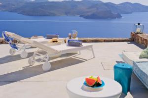 普拉卡米洛斯Odyssey Rock Milos Sunset Suites的露台上摆着一张桌子，上面放着一碗西瓜，可以俯瞰大海