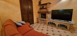 een woonkamer met een bank en een flatscreen-tv bij Monferrato AgriCottage Valentina in Calliano +4 foto's