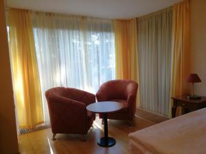a hotel room with two chairs and a table and a bed at Vila Elegancija in Palanga