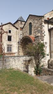 an old stone building with a large brick wall at Le Poulailler in Blesle +8 photos