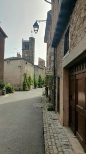 an empty street with a castle in the background at Le Poulailler in Blesle