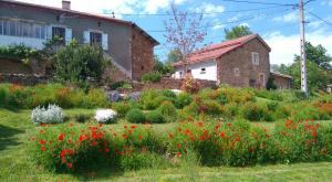 a garden in front of a house with flowers at Le Poulailler in Blesle