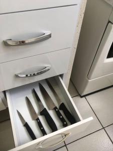 a drawer with knives in it in a kitchen at Apartamento climatizado in Marília