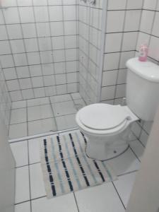 a bathroom with a white toilet and a rug at Apartamento climatizado in Marília +27 photos