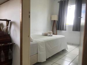 a bedroom with a bed with white sheets and a window at Apartamento climatizado in Marília