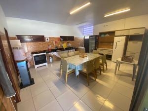 a large kitchen with a table and chairs in it at Casa de Temporada Bem-Viver in Barreirinhas
