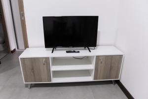 a white entertainment center with a television on top at Viejo Marino Suite in Paraná