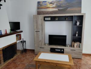 a living room with a tv and a coffee table at Villa Jade Beach in Cala del Moral