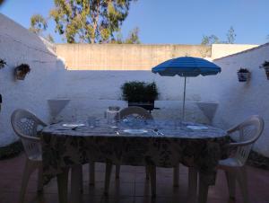 a table with a blue umbrella and chairs at Villa Jade Beach in Cala del Moral