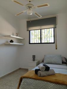 a bedroom with a bed with a fan and a window at Villa Jade Beach in Cala del Moral