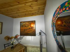 a room with two paintings on the wall and a mirror at Lemona in Stepantsminda