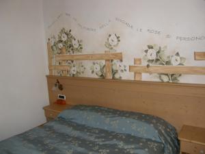 a bedroom with a bed and flowers on the wall at Villa Ilaria in Caderzone