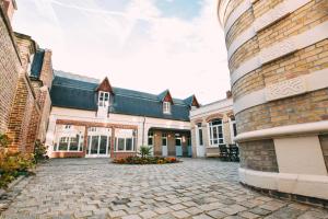 a large brick building with a courtyard with flowers at The Gem in Amiens
