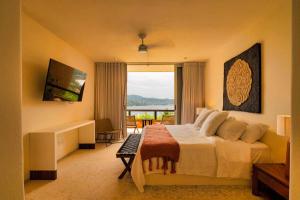 une chambre avec un grand lit avec vue sur l'océan dans l'établissement Armadillo Living Villas, à Zihuatanejo