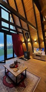 a living room with a table and a tv at Vila Alpine Arlon Gjinar in Gjinar