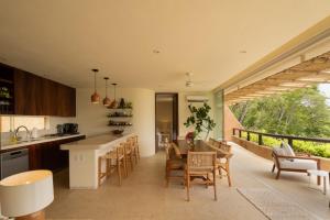 une cuisine et une salle à manger avec une table et des chaises dans l'établissement Armadillo Living Villas, à Zihuatanejo