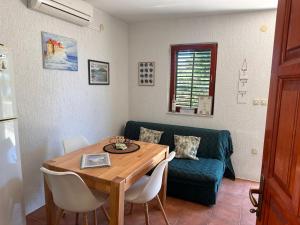salon ze stołem i niebieską kanapą w obiekcie Vacation Home Palma w mieście Rukavac