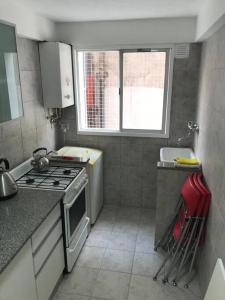 a small kitchen with a stove and a window at Departamento de categoría in Ramos Mejía +7 photos