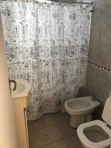 a bathroom with a toilet and a shower curtain at Departamento de categoría in Ramos Mejía