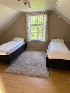 two beds in a room with a window at Nordlandshus Lofoten in Berg