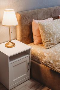a bed with a table with a lamp on it at Old Town Private Room, Shared Bath - D in Tallinn