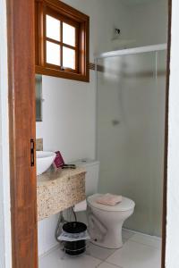 une salle de bain avec toilettes, lavabo et douche dans l'établissement Villa Cottage Pousada, à Monte Alegre do Sul