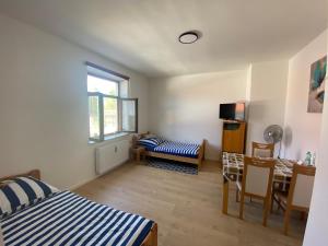 a bedroom with a bed and a table and a window at Appartment im Herzen Bayerns in Bruckmühl
