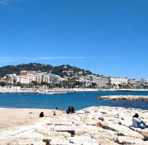 a group of people sitting on a beach at Chambre cosy dans T3 in Cannes